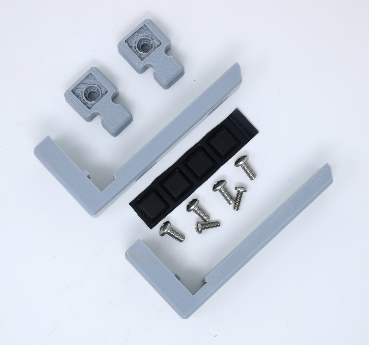 Gray plastic brackets with a black strip and screws on a white background